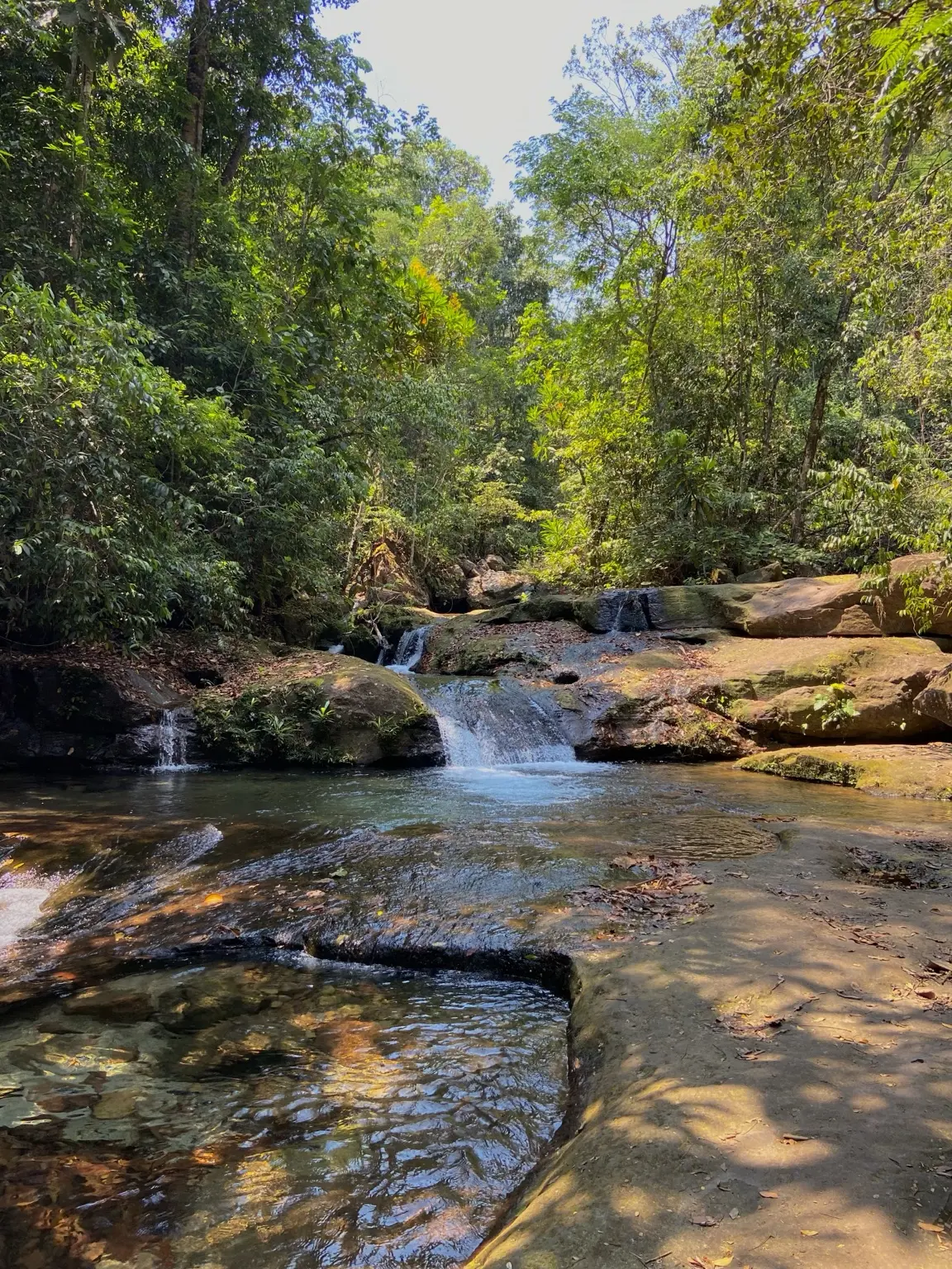 Sequência de cascatas entre pedras e vegetação no percurso