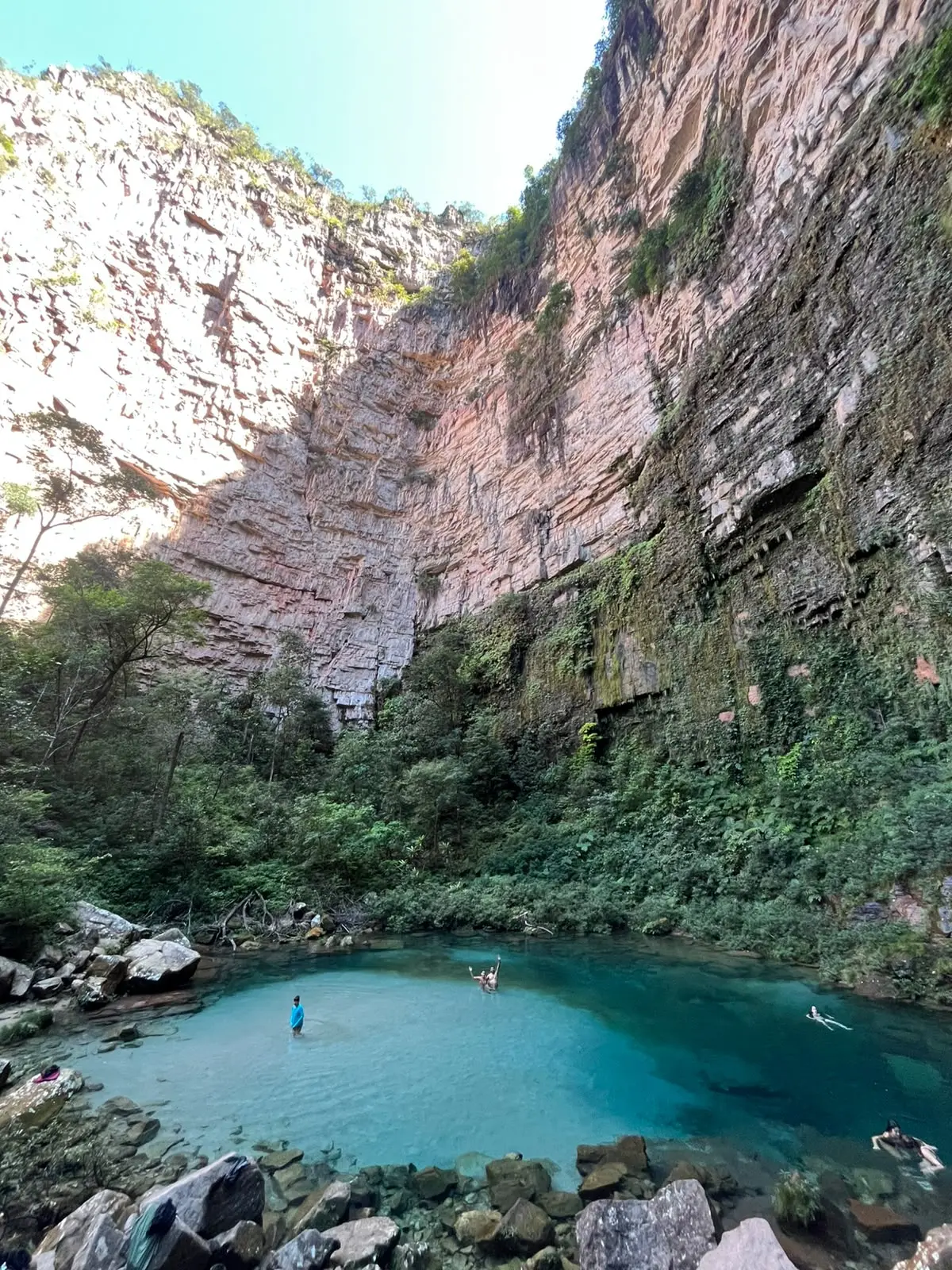 Poço azul do Santuário das Araras com poucas pessoas na água